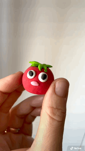 Funny tomato character animation showing a handmade tiny tomato clay figurine with big eyes and stuck out tongue