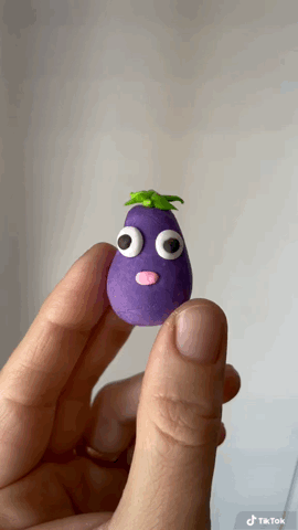 Funny eggplant character animation showing a tiny eggplant clay figurine with big eyes and stuck out tongue