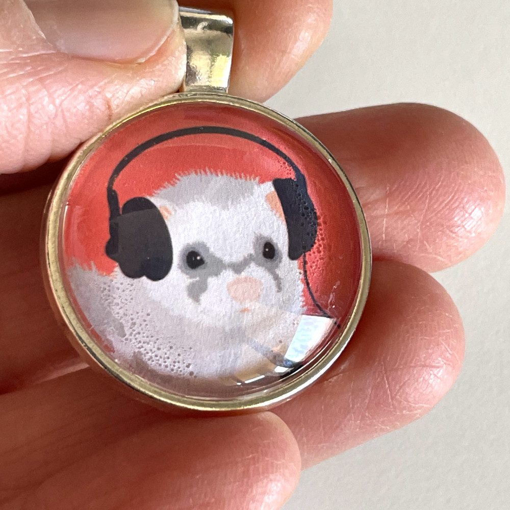 Cabochon necklace fail - spots where I have not put a sufficient amount of the decoupage glue on. this handmade pendant with a funny ferret illustration