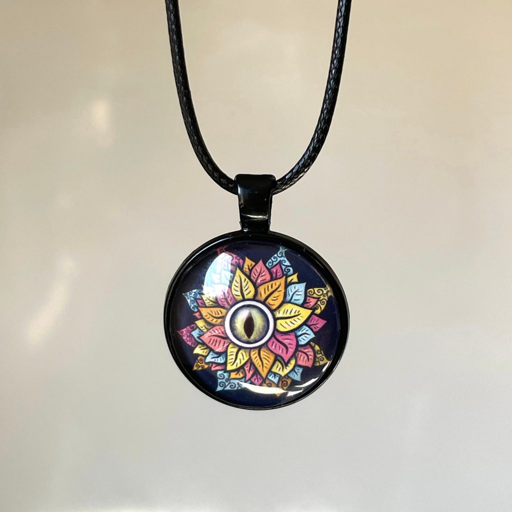 Handmade cabochon necklace with a black string and bezel and original art of a colorful eye flower