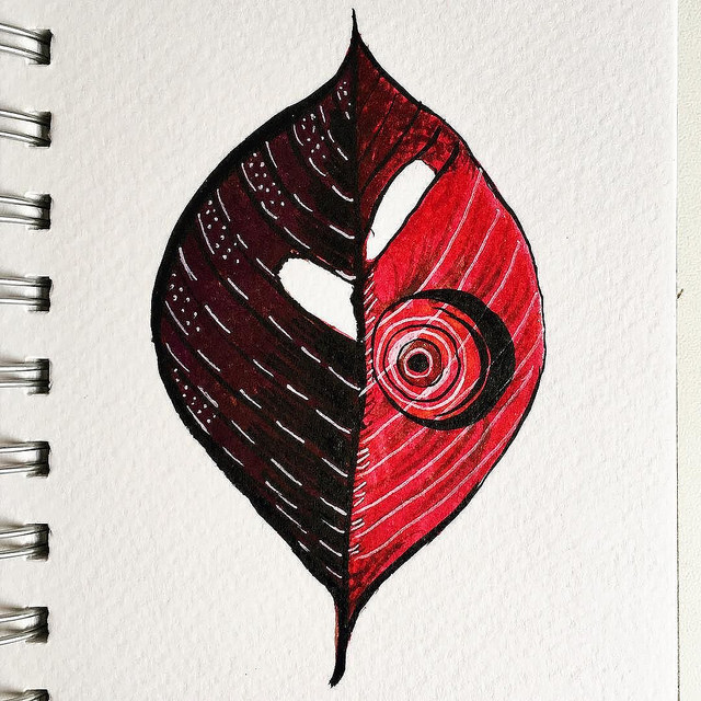 ink drawing of a leaf with two different colors halves and white decorative circles