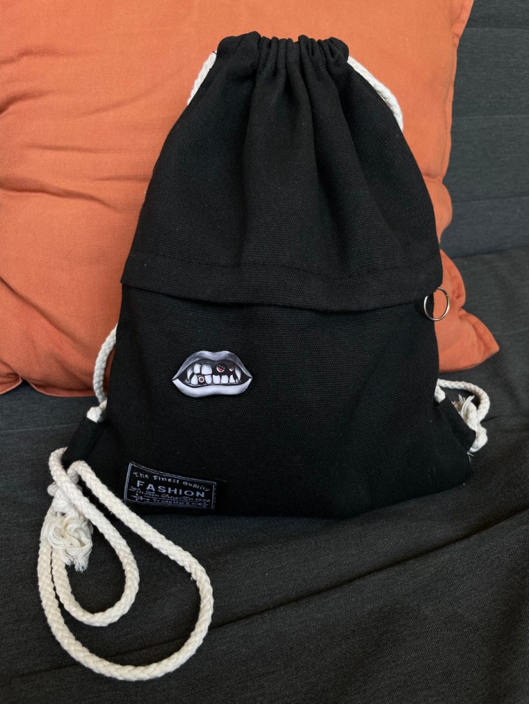 vampire lips handmade pin on black drawstring bag