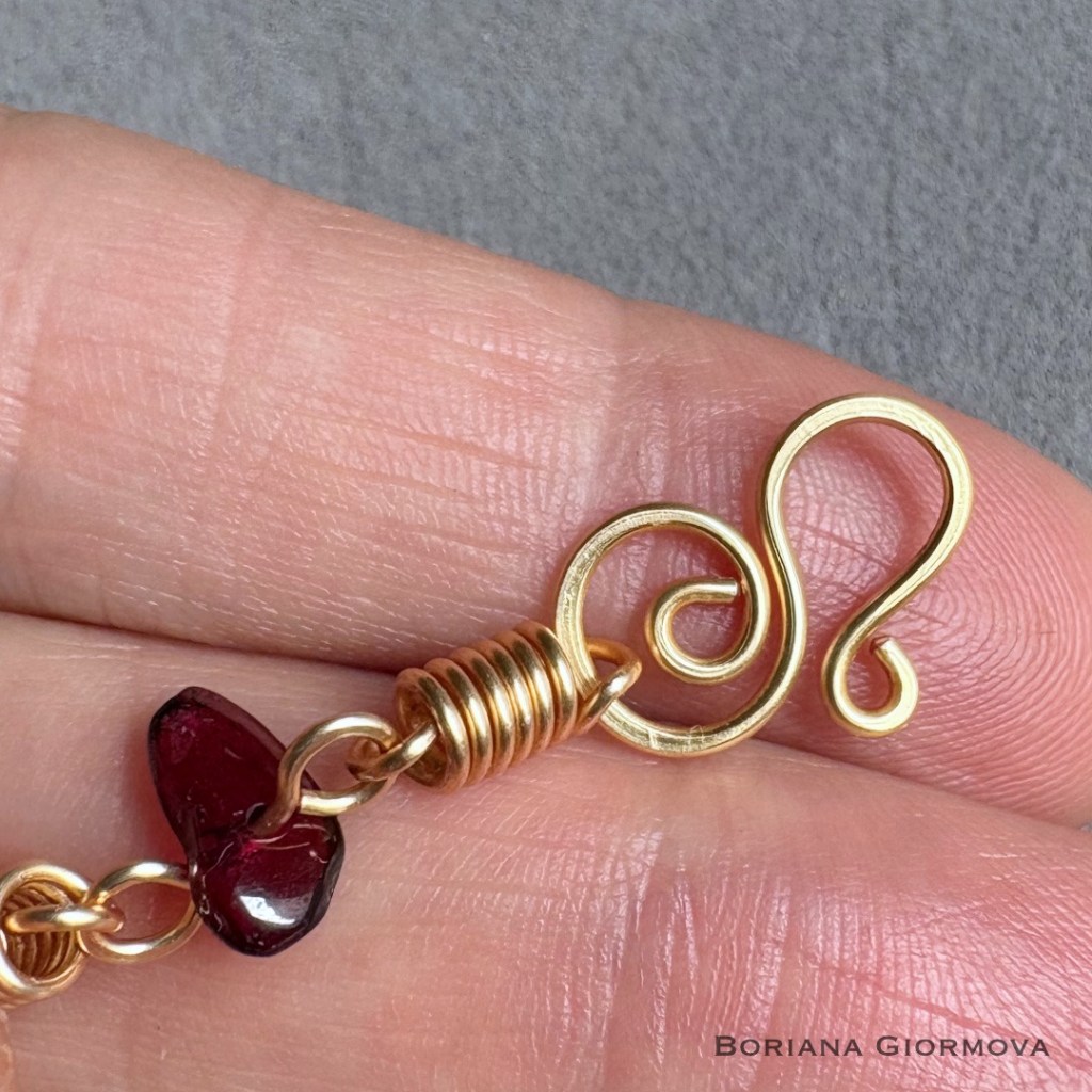 Handmade clasp element made of colored copper wire with spiral and hook