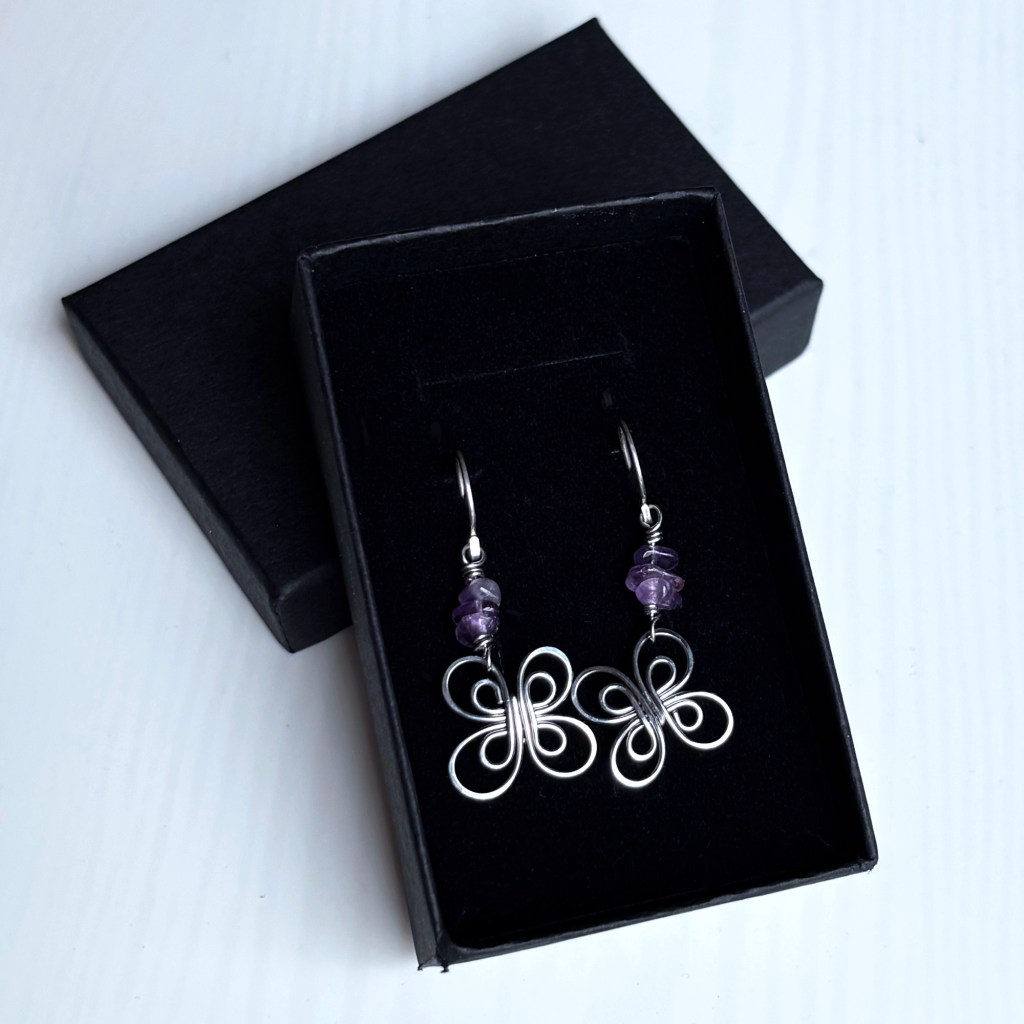 amethyst earrings with flowers in a black jewelry box