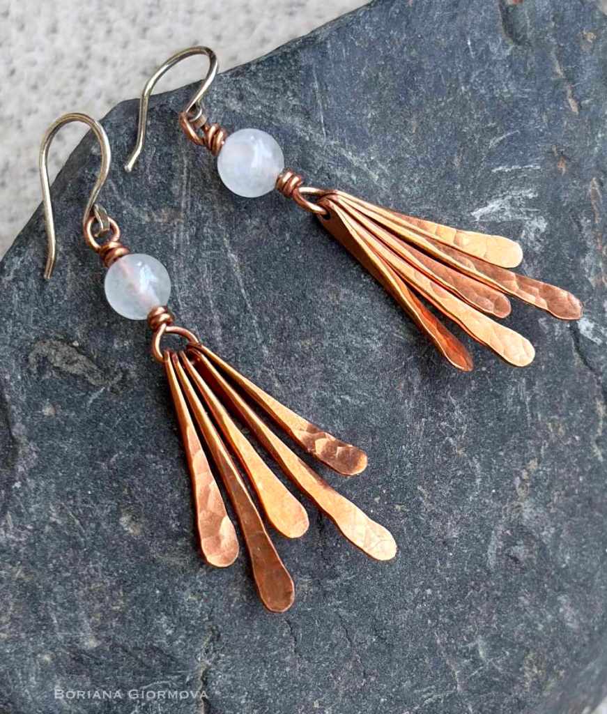 fringe copper earrings with natural white moonstone gem beads photographed on a dark stone