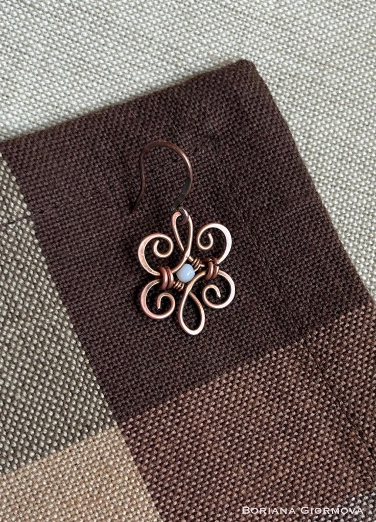 Rustic Copper Earring with mother of pearl on brown linen fabric