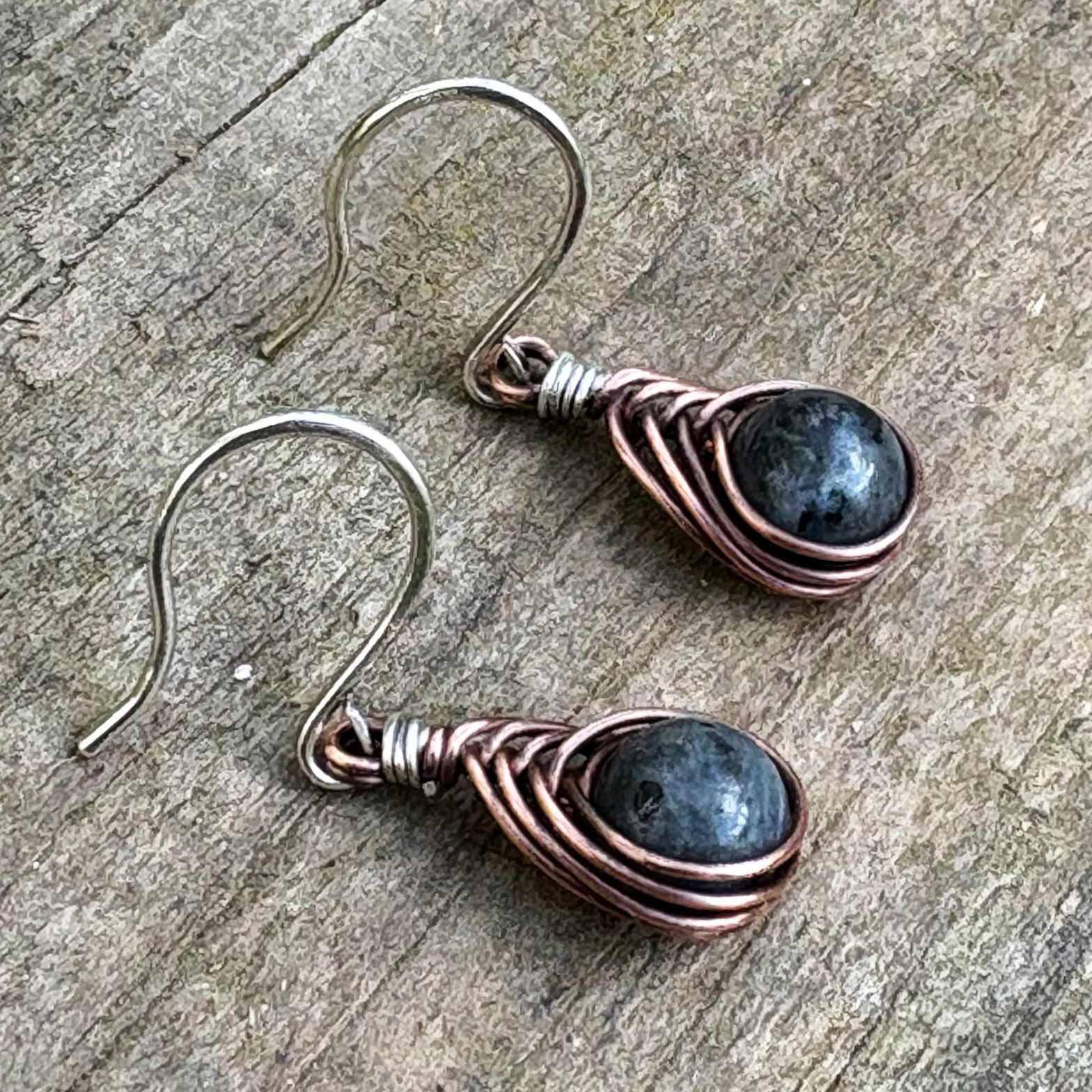 close up of boho earrings with oxidized copper, labradorite stones and silver hooks , shot on wood