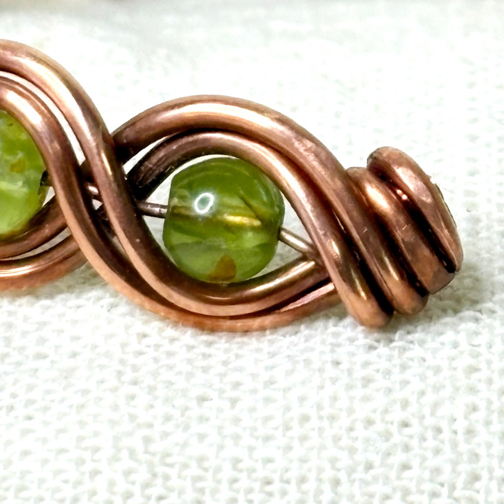 handmade copper cuff bracelet - wire woven with green peridot stones - detail on the ending
