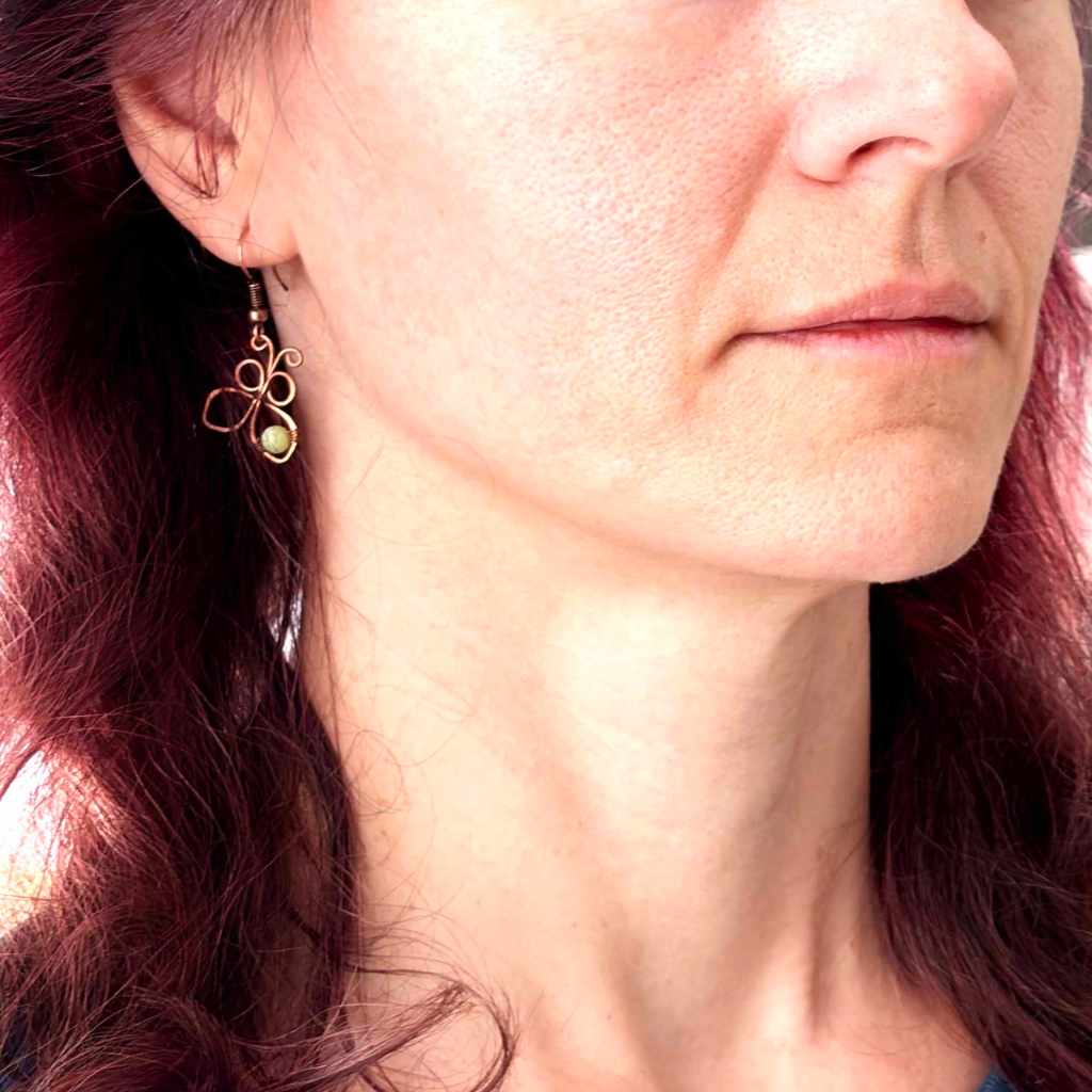 Handmade copper butterfly earring worn on the ear, showing the size and shape when worn