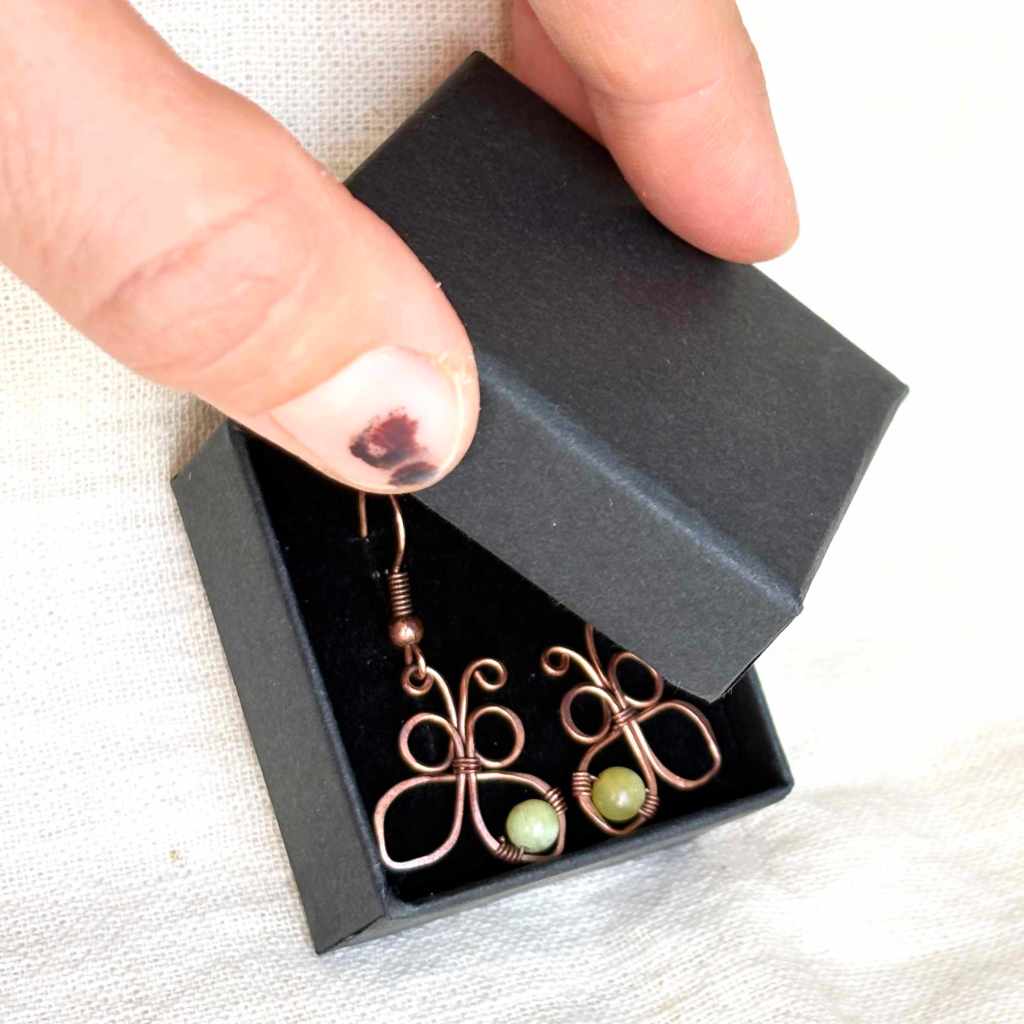 Handmade copper butterfly earrings presented inside a black jewellery box, ready for gifting